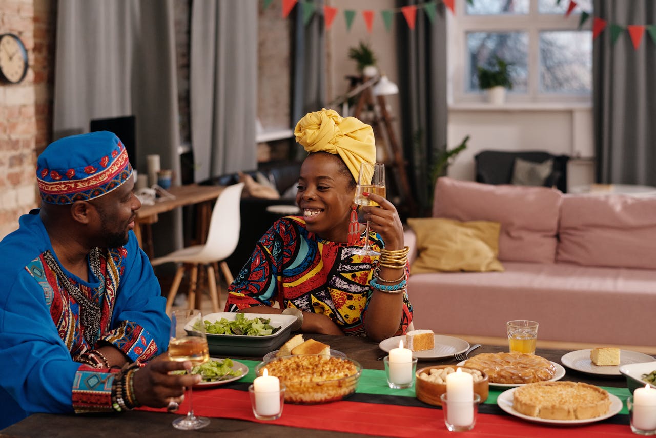 African American couple celebrates Kwanzaa with traditional food and joy.